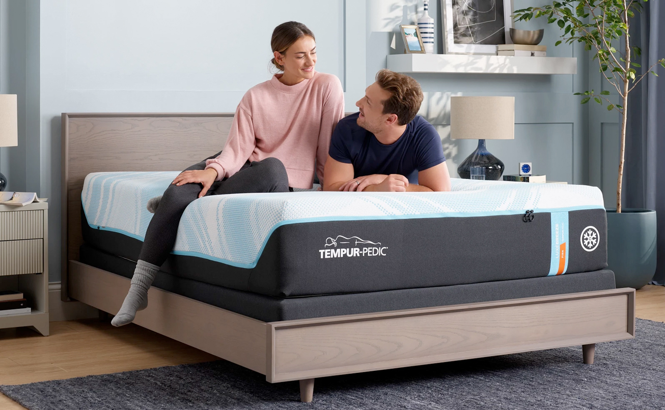 An image with a couple relaxing on their Tempur-Pedic mattress.